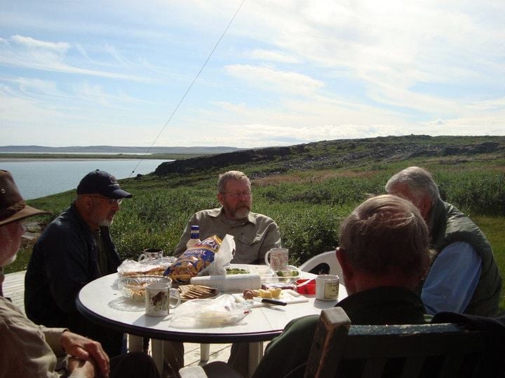 A bunch of the boys chomping on snacks at Whittakers' place at the mouth of the Coppermine River after a lovely canoe trip.